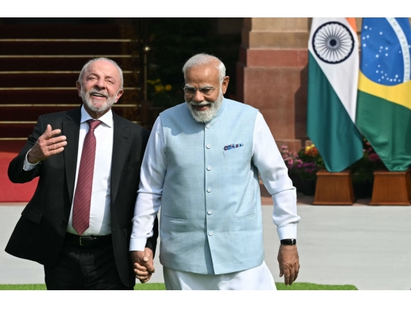 India's Prime Minister Narendra Modi (R) holds hands with Brazil's President Luiz Inacio Lula da Silva as they walk before their meeting at the Hyderabad House in New Delhi on February 21, 2026. (Photo by Sajjad Hussain / AFP)
