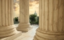US Capitol building viewed between columns of the Supreme Court at sunset.