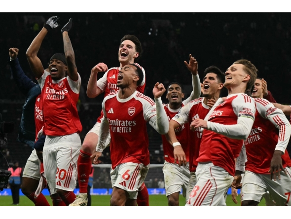 Arsenal celebrate their victory at the end of the English Premier League football match between Tottenham Hotspur and Arsenal at the Tottenham Hotspur Stadium in London, on February 22, 2026. (Photo by Glyn KIRK / AFP)