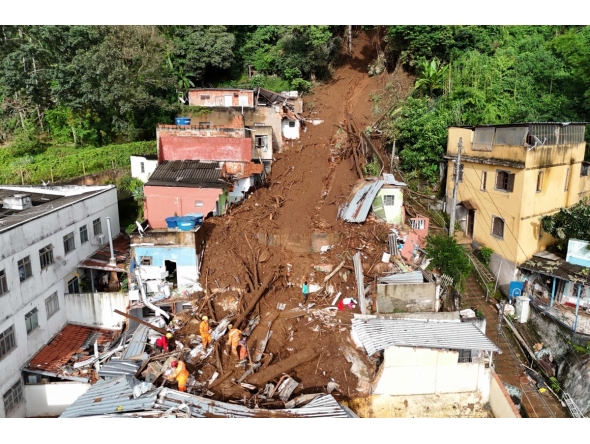 In this aerial view rescuers search for victims amid the rubble and mud of a house after a landslide triggered by heavy rains in the Paineiras neighborhood in Juiz de Fora, Minas Gerais State, Brazil, on February 25, 2026. Photo by Pablo PORCIUNCULA / AFP