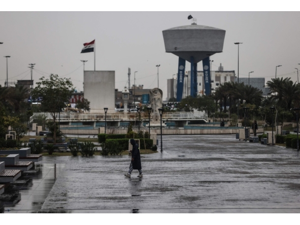 An Iraqi man walks through Al-Umma Park during rainfall in Baghdad on March 15, 2026. (Photo by AHMAD AL-RUBAYE / AFP)