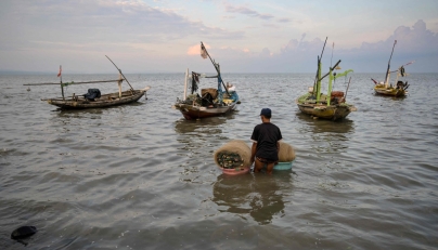 A man prepares to go fishing in Surabaya on March 30, 2026. (Photo by JUNI KRISWANTO / AFP)