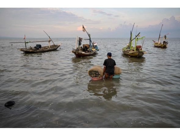 A man prepares to go fishing in Surabaya on March 30, 2026. (Photo by JUNI KRISWANTO / AFP)