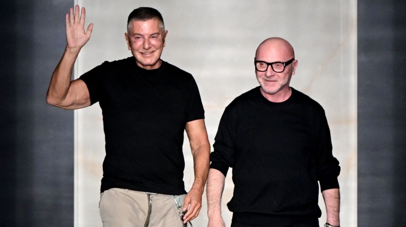 Italian stylists Domenico Dolce (R) and Stefano Gabbana (L) salute the audience at the end of the Dolce & Gabbana women's ready-to-wear Fall/Winter 2026 collection show as part of the Milan Fashion Week, in Milan on February 28, 2026. Photo by Miguel MEDINA / AFP