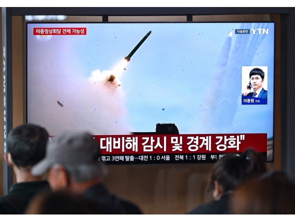People watch a television screen showing a news broadcast with file footage of a North Korean missile test, at a train station in Seoul on April 19, 2026. Photo by Jung Yeon-je / AFP