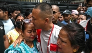 Sudan Gurung (C), a key figure among the Gen Z protesters, meets with family members of a victim, who died during anti-corruption clashes with security personnel, outside the Tribhuvan University Teaching Hospital in Kathmandu on September 13, 2025. Photo by Arun SANKAR / AFP