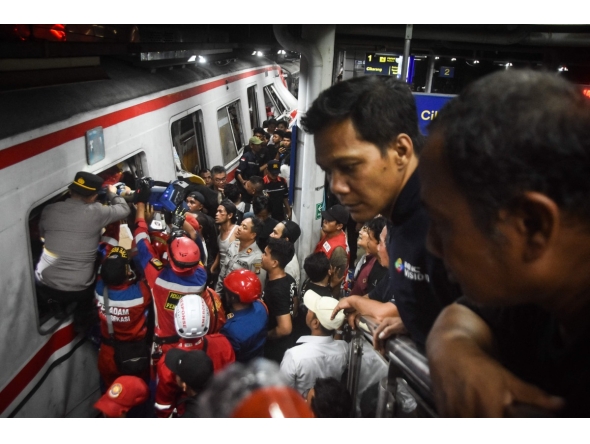 Rescuers work at the site of a train collision after a passenger train locomotive pierced through the rear car of a commuter train at Bekasi Timur station in Bekasi, West Java on April 28, 2026. (Photo by Rezas / AFP)