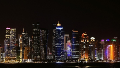 Illuminated skyscrapers are pictured along the corniche promenade in Doha on May 15, 2026. (Photo by Karim JAAFAR / AFP)
