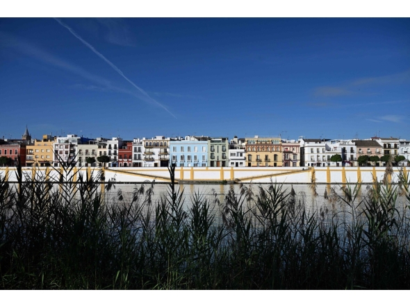 A picture taken on April 30, 2026 shows residential buildings alongside the Guadalquivir river on Betis street in Seville. Photo by CRISTINA QUICLER / AFP