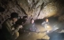 This screengrab made from handout video footage taken on May 29, 2026, shows a rescue team (C, R) about to free one (L) of seven men trapped in a semi-submerged cave. (Photo by Handout / Benz Norrased Palasing / Seascout Diving / AFP) 