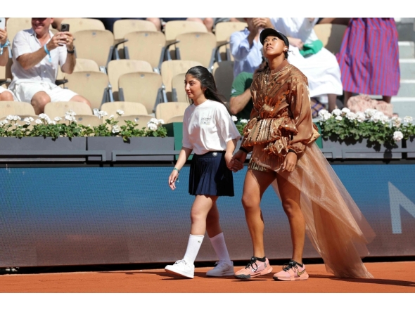 Japan's Naomi Osaka walks on court with a mascot for her women's singles match at the Roland-Garros Complex in Paris on May 30, 2026. (Photo by Thomas Samson / AFP)