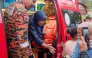 This handout photo taken and released by Perak's Fire and Rescue Department on June 6, 2026, shows rescuers assisting Jaslinda Saludin (2nd L) after she was found in a forested area in central Malaysia's Perak state. (Photo by Handout / Perak's Fire and Rescue Department / AFP)