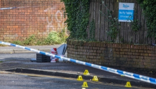 Police forensic marks are pictured behind a cordon at the scene of a stabbing on Kinnaird Avenue in north Belfast, Northern Ireland, on June 9, 2026. Photo by Paul Faith / AFP