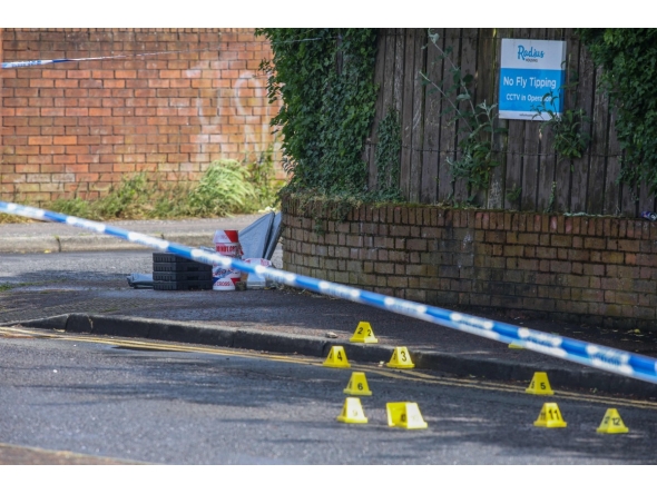 Police forensic marks are pictured behind a cordon at the scene of a stabbing on Kinnaird Avenue in north Belfast, Northern Ireland, on June 9, 2026. Photo by Paul Faith / AFP