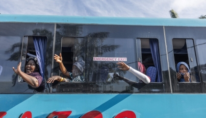 Migrants wave to people their goodbyes as the first of seven buses leave the Sherwood Park in Durban on June 14, 2026. (Photo by RAJESH JANTILAL / AFP)
 