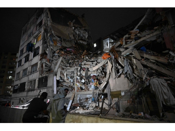 People look at a collapsed building in the Altamira neighbourhood following an earthquake in Caracas on June 24, 2026. (Photo by Federico PARRA / AFP)
 