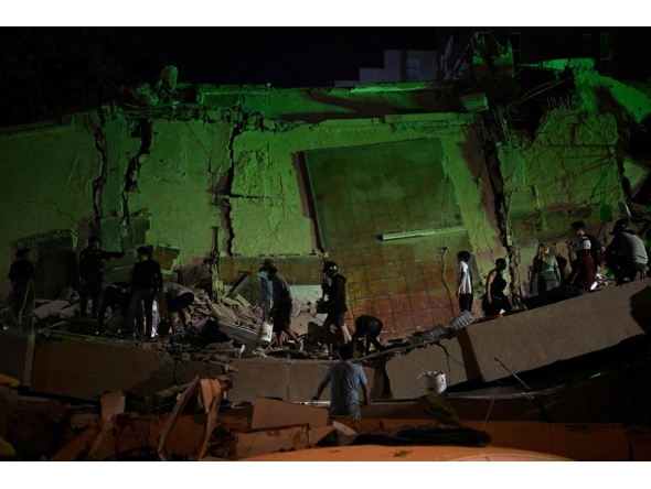 Rescue workers search through the rubble of a collapsed building in the Altamira neighbourhood following an earthquake in Caracas on June 24, 2026. (Photo by Federico ParraARRA / AFP)