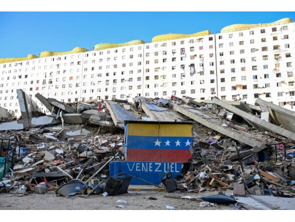 A Venezuelan flag is seen painted on a damaged wall amid the rubble of a collapsed building following earthquakes in Caraballeda, La Guaira state, Venezuela, on June 26, 2026. (Photo by Maryorin Mendez / AFP)