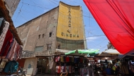 Street vendors gather outside the faded facade of the Granada Cinema, an early 1940s landmark, in the Bab al-Sharqi district of central Baghdad on May 26, 2026. (Photo by Ahmad Al-Rubaye/ AFP)
