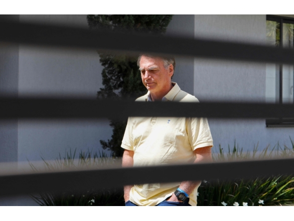 (FILES) Former Brazilian President Jair Bolsonaro gestures from his residence in Brasilia on September 3, 2025. (Photo by Sergio Lima / AFP)
