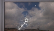 This picture shows a bullet hole on the window of a restaurant after it was burned down by settlers during an attack in the western area of the Al-Lubban ash-Sharqiya village, south of Nablus, in the occupied West Bank on on July 5, 2026. (Photo by JAAFAR ASHTIYEH / AFP)