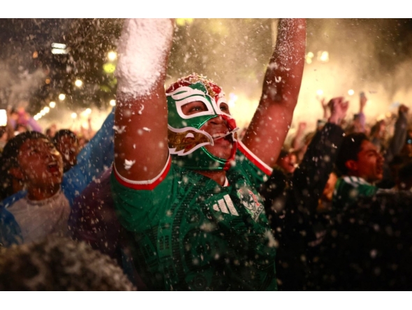 A masked Mexican football fan reacts as they watch the 2026 FIFA World Cup Round of 16 football match between Mexico and England at the Angel of Independence in Mexico City on July 5, 2026. (Photo by Claudia Rosel / AFP)