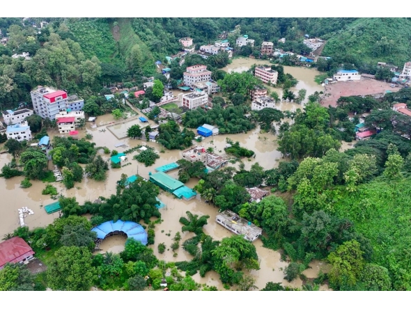 This aerial photograph shows partially submerged residential buildings following heavy rains in Bangladesh's Bandarban town on July 11, 2026. (Photo by Syed Amir Hosain Masum / AFP)