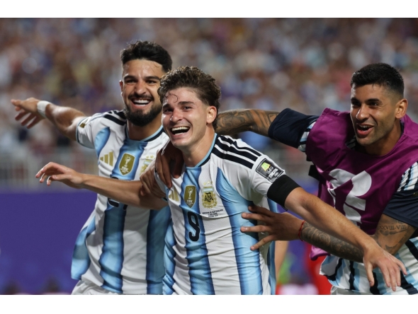 Argentina's forward #09 Julian Alvarez (C) celebrates scoring his team's second goal with Argentina's forward #21 Jose Manuel Lopez (L) and Argentina's defender #13 Cristian Romero. Photo by Odd Andersen / AFP