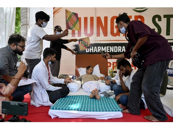Cockroach Janta Party (CJP) founder Abhijeet Dipke (2R) reacts as doctors check activist Sonam Wangchuk vital signs during his hunger strike in New Delhi on July 15, 2026, demanding the resignation of India Education Minister Dharmendra Pradhan over alleged examination irregularities. (Photo by Arun SANKAR / AFP)
 