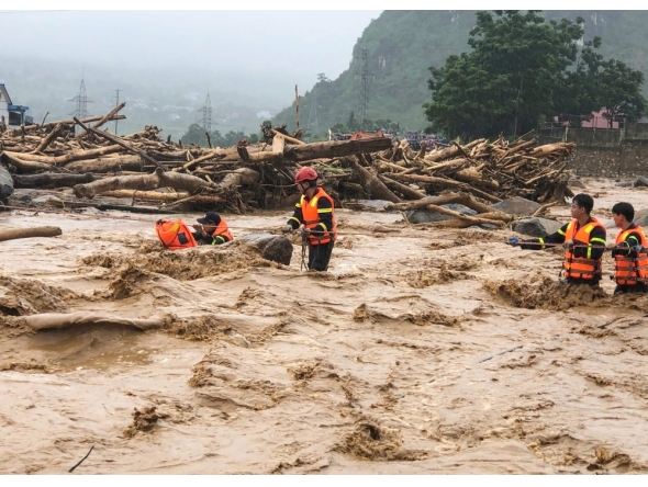 This photo taken and released by Vietnam News Agency (VNA) on July 17, 2026, shows rescue workers addressing the aftermath of flash floods in Muong Than Commune, Lai Chau Province, northern Vietnam. (Photo by Vietnam News Agency (VNA) / AFP)