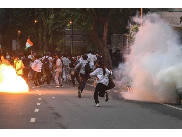 Rapid Action Force (RAF) personnel fire tear gas shells to disperse supporters of the Cockroach Janta Party (CJP) during a protest demanding the resignation of India's Education Minister Dharmendra Pradhan over alleged NEET exam irregularities in New Delhi on July 20, 2026. (Photo by Arun SANKAR / AFP)