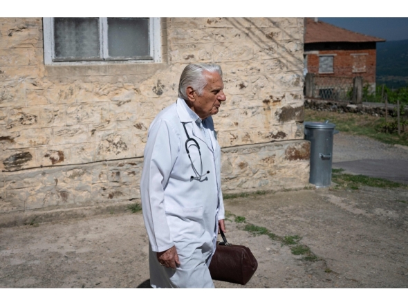 Dr. Apostolov, 90, a general practitioner, leaves his consulting room to visit a patient in the village of Skrat, in the foothills of the Belasitsa Mountains on July 15, 2026. (Photo by Nikolay Doychinov / AFP)