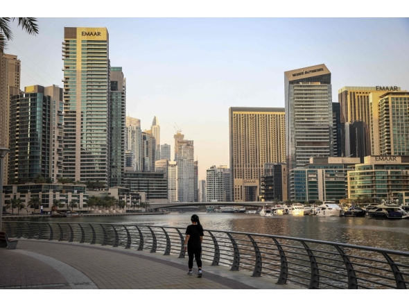 A woman walks through Dubai's Marina district on July 21, 2026. (Photo by Fadel Senna / AFP)