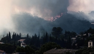 Flames spread on the hills surrounding Cotignac, southeastern France on July 23, 2026 during a wildfire. (Photo by Thibaud MORITZ / AFP)