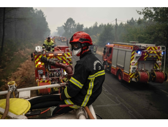 Firefighters operate from a column of firefighters vehicles near the town of Lacanau, in southwestern France on July 25, 2026. (Photo by Julien De Rosa / AFP)