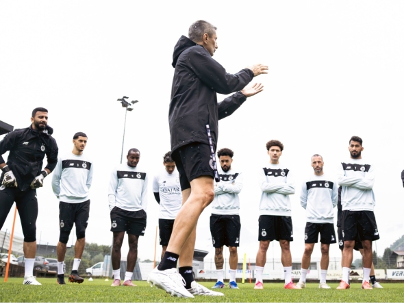 Al Sadd's coach Razvan Lucescu with players during a training session yesterday.