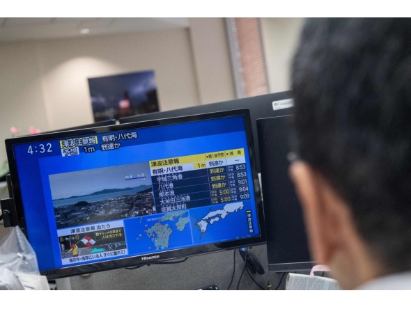 Reporters watch the news showing a large quake and possible one meter tsunami wave in Southern Japan, from an office in Tokyo on July 28, 2026. Photo by Andrew Caballero-Reynolds/ AFP