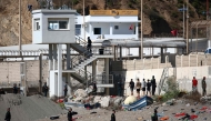 Some migrants arrive at the border post with the intention of crossing back into Morocco as members of the Spanish armed forces keep watch over the area in the Spanish enclave of Ceuta on August 2, 2026. (Photo by Henry Nicholls / AFP)
 