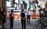 Police community support officers (PCSOs) stand behind cordon tape at Endell road in covent garden, central London on August 5, 2026. Photo by Henry NICHOLLS / AFP