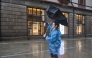 A man uses an umbrella to shelter from the rain on the Bund a day after Typhoon Dolphin made landfall in Shanghai on August 10, 2026. (Photo by Hector RETAMAL / AFP)