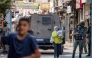 A Palestinian woman carrying a child walks past members of the Israeli occupation army and armoured vehicles during an Israeli military operation at the Balata camp for Palestinian refugees, east of Nablus in the occupied West Bank, on August 31, 2026. Photo by JAAFAR ASHTIYEH / AFP