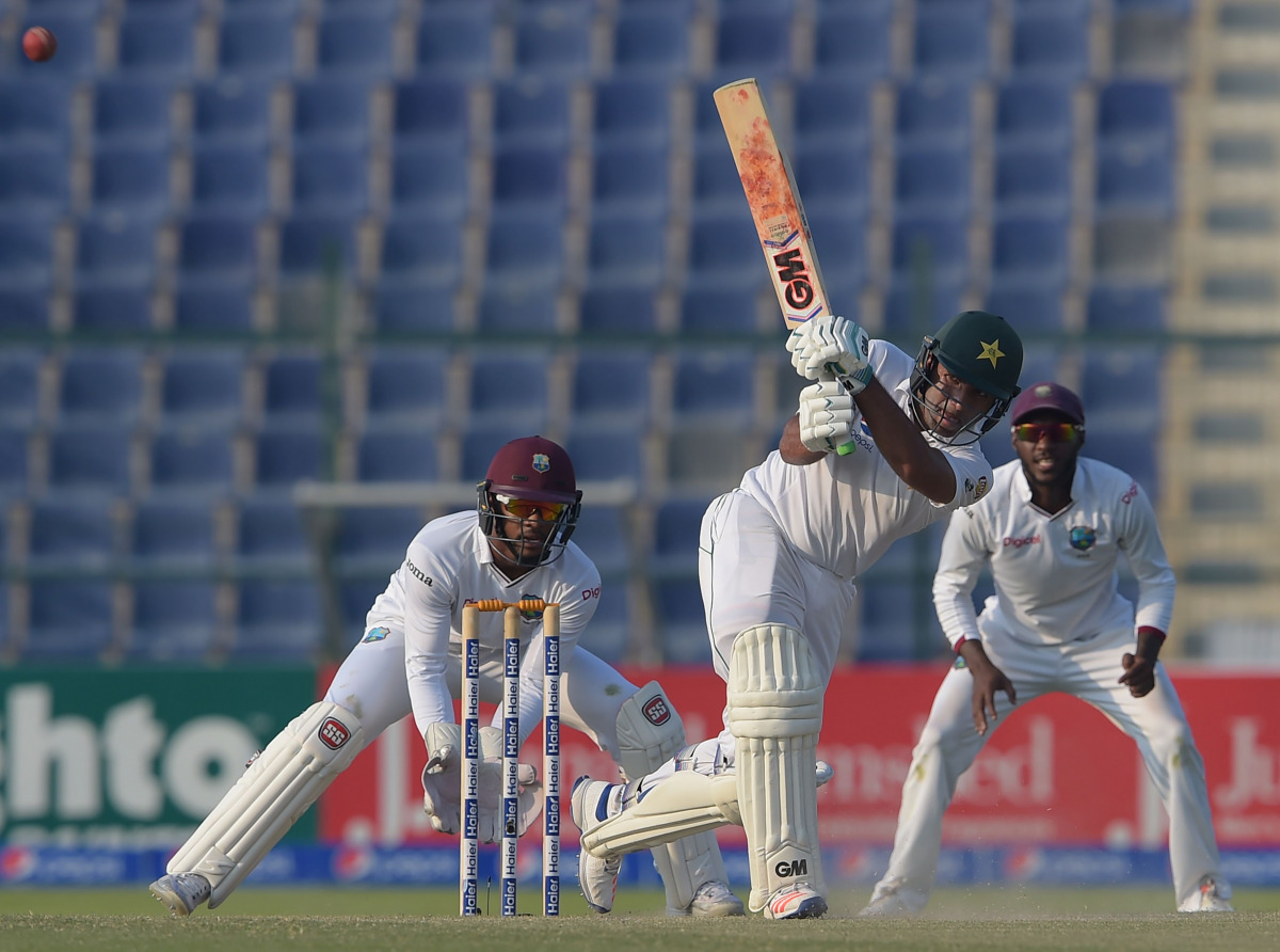 Pakistani batsman Sami Aslam (C) plays a shot as West Indies' wicketkeeper Shai Hope (L) looks on during the third day of the second Test between Pakistan and the West Indies at the Sheikh Zayed Cricket Stadium in Abu Dhabi on October 23, 2016. (AFP / AAM