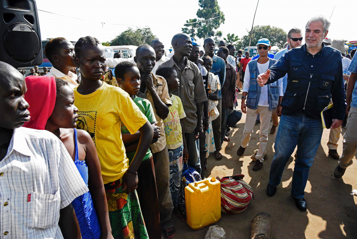 EU Commissioner for Humanitarian and Crisis Management, Christos Stylianides speaks with newly arrived refugees from South Sudan as they queue in line waiting to be registered on November 11, 2016 at Kuluba Reception Centre in Koboko District, North of th