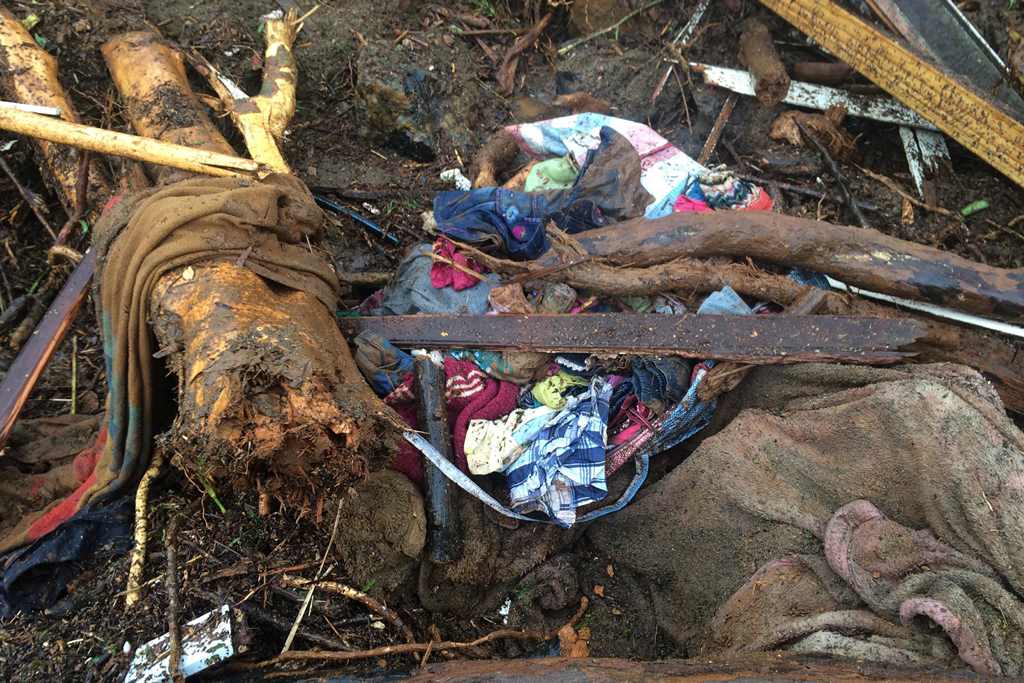 Belongings are caught in branches and landslide mud on November 22, 2016 in the village of Ouakaya in the Houailou area, around 235 kilometres (150 miles) northwest of the capital Noumea, on the eastern coast of New Caledonia, after rain battered the area