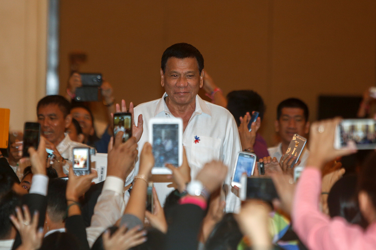 Philippine President Rodrigo Duterte greets people before a meeting with the Filipino Community at a hotel in Phnom Penh, December 13, 2016. REUTERS/Samrang Pring