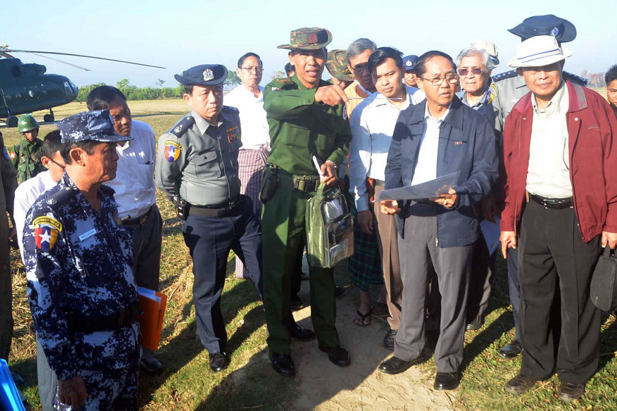This handout photograph taken on December 12, 2016 and released on December 13, 2016 by the Myanmar State Counsellor Office shows a military official (C) briefing Myanmar Vice President Myint Swe (2nd R, in blue jacket), head of the Rakhine State Investig