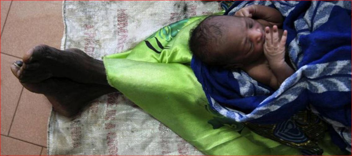 In this 2007 photo, a woman holds her newborn grandson as she sits on the floor of Lacor hospital's maternity ward in northern Uganda. REUTERS/Euan Denholm