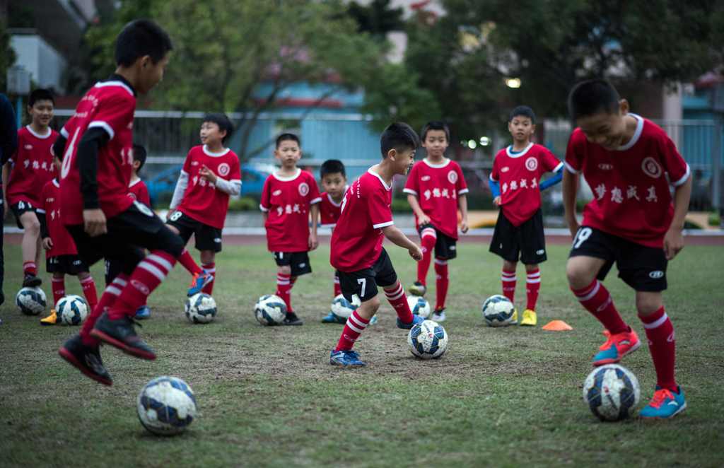 (FILES) This file photo taken on January 12, 2016 shows children attending a football training session in the suburbs of Guangzhou in southern China's Guangdong province.  AFP / JOHANNES EISELE 
