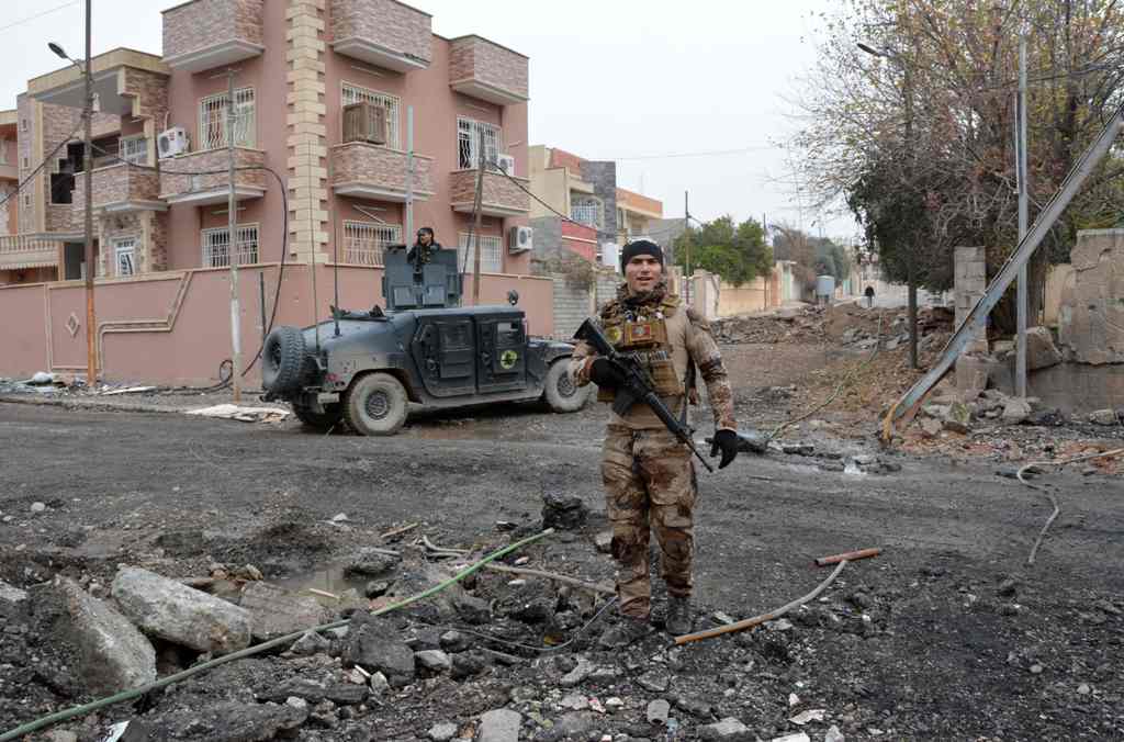 A member of Iraqi special forces poses in the neighbourhood of al-Barid east of Mosul on December 18, 2016 during their ongoing operation against Islamic State (IS) group jihadists to wrest back the city. / AFP / Mahmoud AL-SAMARRAI
