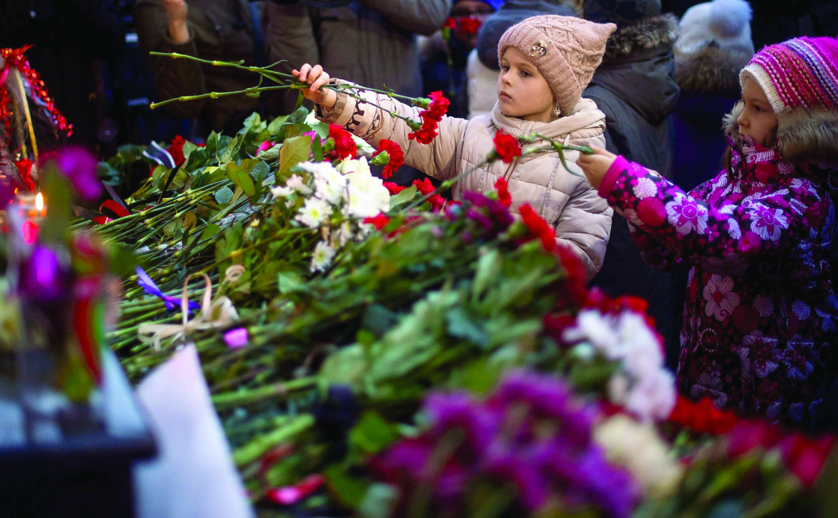 Two girls lay flowers at the home stage building of the Alexandrov Ensemble (The Red Army Choir), in Moscow.